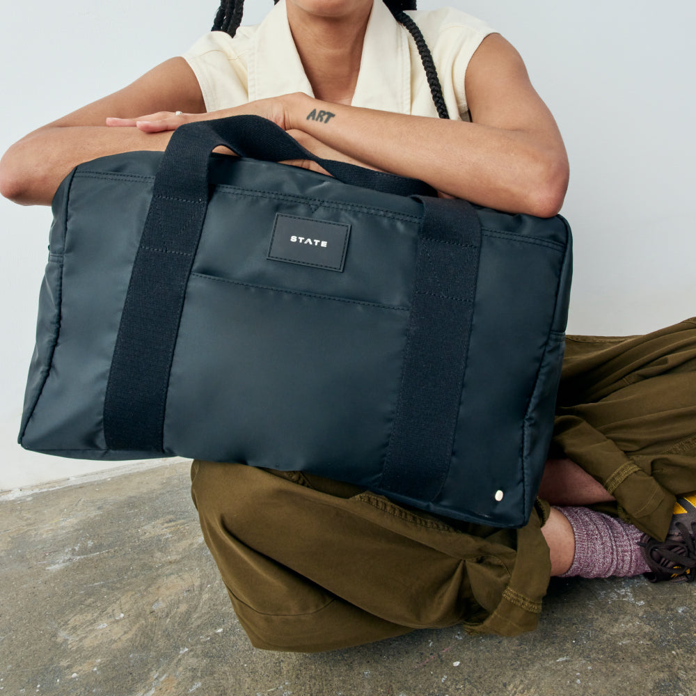 Woman holding STATE Bags Wellington Weekender Black