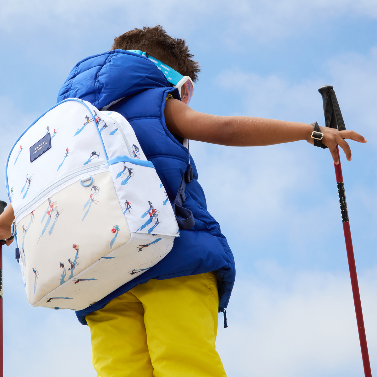 Boy wearing Kane Backpack Ski with ski poles