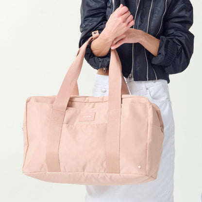 Womna holding STATE Bags Wellington Weekender Latte