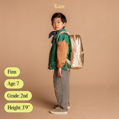 Boy wearing STATE Bags Kane Backpack with name, age, grade, and height listed