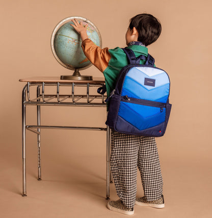 Boy wearing navy backpack playing with globe